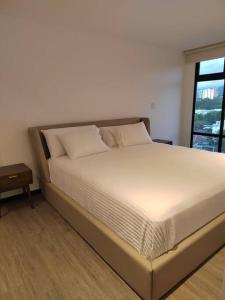 a large bed in a room with a window at Hermoso apartamento nuevo en zona 10! in Guatemala