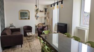 a living room with a couch and a tv at Le Puy de Côme in Saint-Diéry
