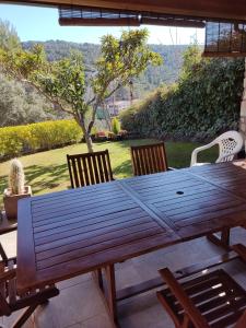 einen Holztisch und Stühle auf einer Terrasse in der Unterkunft Casa Rural Lago Bolarque in Albalate de Zorita