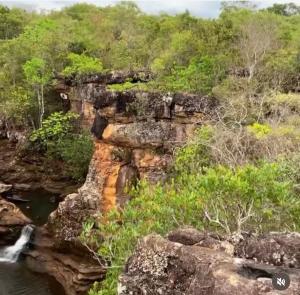 einen Wasserfall auf einer Klippe neben einem Fluss in der Unterkunft Pousada Villa Rica in Carolina