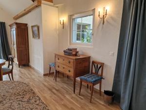 a room with a dresser and chairs and a window at Le Debarcadere in Saint-Sulpice