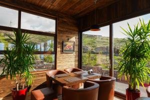 a dining room with a table and chairs and windows at Amberd Hotel in Byurakan