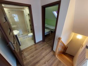 an open door to a bathroom with a staircase and a mirror at Apartament Południowy in Debina