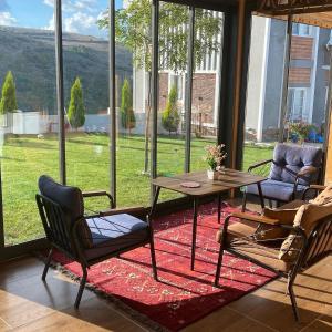 ein Wohnzimmer mit einem Tisch und Stühlen sowie einem großen Fenster in der Unterkunft Öztürk Farm House in Samsun