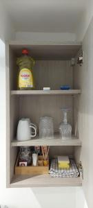 a shelf in a kitchen with dishes and glasses at The Chapel House in Saint Helens