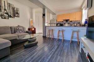 a living room with a couch and a kitchen at Superbe appartement avec jardin proche Versailles in Saint-Cyr-lʼÉcole