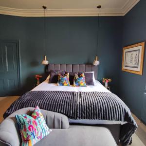 a bedroom with a large bed with blue walls at Merchant House in Bootle