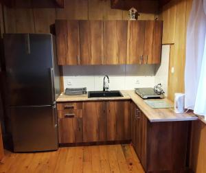 a kitchen with wooden cabinets and a stainless steel refrigerator at Zakątek nad Sanem, Załuż 128 in Załuż +15 photos