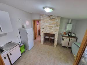 a kitchen with a stone fireplace and a refrigerator at Casa rural cerca Tarancón-Cuenca in Saelices