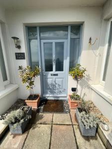 a front door of a house with potted plants at Sea views Family & Relocators by O & J Properties in Shoreham-by-Sea