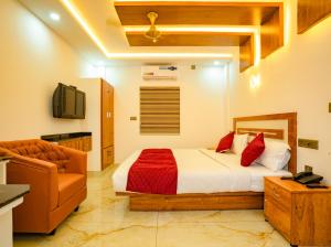 MARINA SUITES AIRPORT HOTEL في كوتشي: غرفة نوم بسرير واريكة وتلفزيون