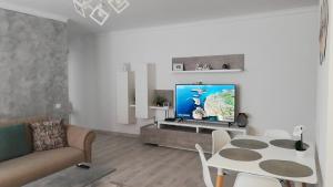 sala de estar con sofá, TV y mesa en Happy Home, en Târgu Mureș