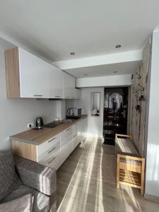 a kitchen with white cabinets and a couch in a room at Mia in Rēzekne