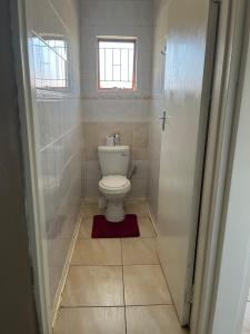 a small bathroom with a toilet and a window at Angelmalatji guesthouse in Graskop