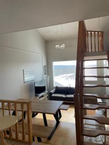 - un salon avec un escalier et un canapé dans l'établissement Näköalahuoneisto AARNI & NAAVA, à Ukkohalla