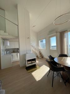 een woonkamer met een keuken en een tafel en stoelen bij Näköalahuoneisto AARNI & NAAVA in Ukkohalla