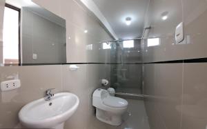 Baño blanco con lavabo y aseo en PRIVATE ROOMS / DOWNTOWN AREQUIPA, en Arequipa