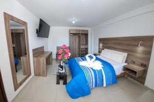 1 dormitorio con 1 cama y un jarrón de flores en PRIVATE ROOMS / DOWNTOWN AREQUIPA, en Arequipa