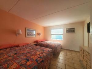 a hotel room with two beds and a window at Caprice Motel - Wildwood in Wildwood