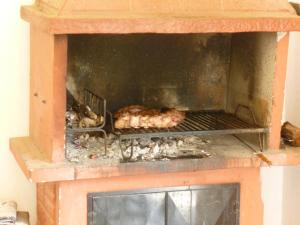 a chicken is cooking in a brick oven at Cabañas del Sol in Potrerillos