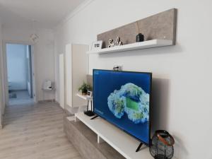 TV de pantalla plana en la pared de la sala de estar. en Happy Home, en Târgu Mureș