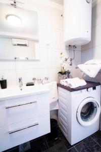 ein Badezimmer mit einer Waschmaschine und einem Waschbecken in der Unterkunft Apartman NONO in Splitska