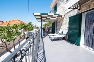 - un balcon avec des chaises et un parasol dans un bâtiment dans l'établissement Apartman NONO, à Splitska