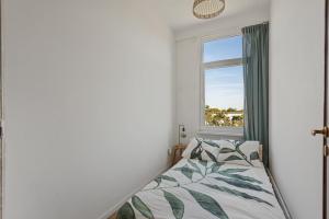 1 dormitorio con cama y ventana en Cozy Antwerp - Sunny Zurenborg, en Amberes