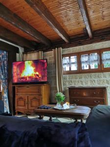 uma sala de estar com uma televisão e uma mesa de centro em Le gîte du Brouage em Chauny