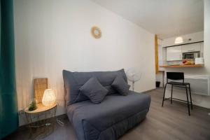 Appartement tout équipé à coté/Vieux port/Noailles في مارسيليا: غرفة معيشة مع أريكة زرقاء وطاولة