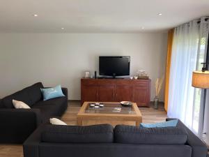 een woonkamer met 2 banken en een salontafel bij Maison proximité Golf et plage de Bréville sur Mer in Bréville-sur-Mer