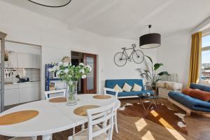 una cucina e un soggiorno con tavolo e sedie bianchi di Cozy Antwerp - Sunny Zurenborg ad Anversa