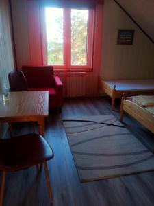 a room with a bed and a table and window at Agroturystyka u Basi in Burniszki