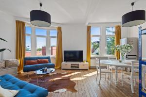 un soggiorno con divano blu e tavolo di Cozy Antwerp - Sunny Zurenborg ad Anversa