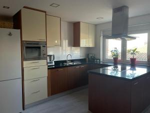 a kitchen with wooden cabinets and a black counter top at IGiDELUX in Era de Soler +6 photos