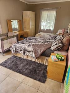 - une chambre avec un lit et un tapis dans l'établissement Tjokkerland, à Cradock