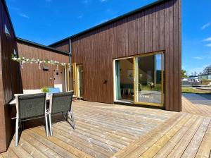 Fresh hytte ved Borestranden med to soverom og hems في Klepp: سطح مع كرسيين وطاولة على مبنى