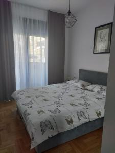 a bedroom with a bed with a comforter on it at Harmony Suite in Trebinje