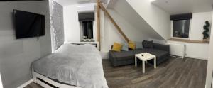 un piccolo soggiorno con letto e divano di Apartament Bronowice a Cracovia