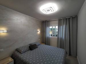 een kleine slaapkamer met een bed en een raam bij Holiday Apartment Alegranza in Playa del Inglés