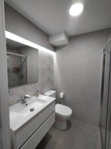 een witte badkamer met een toilet en een wastafel bij Holiday Apartment Alegranza in Playa del Inglés