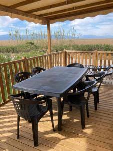 une table et des chaises noires sur une terrasse dans l'établissement Mobil home 3 chambres mar estang 4 étoiles !, à Canet