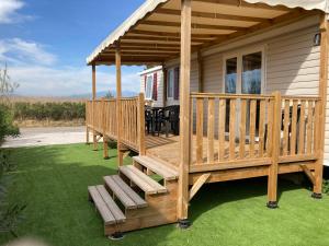 ein Haus mit einer Terrasse mit einem Tisch und Stühlen in der Unterkunft Mobil home 3 chambres mar estang 4 étoiles ! in Canet-en-Roussillon