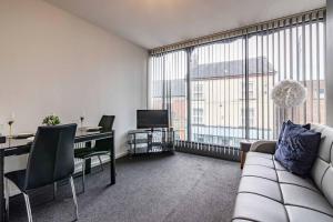 a living room with a couch and a desk with a television at Luxury stay in EastwoodTown centre in Eastwood