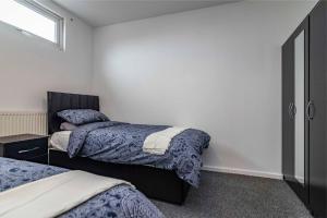 a bedroom with two beds and a window at Luxury stay in EastwoodTown centre in Eastwood