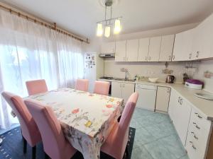 een keuken met een tafel met roze stoelen en een tafel en een keuken met bij Ksenija in Novi Vinodolski