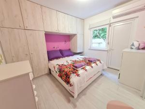 - une chambre avec un lit doté d'une tête de lit violette dans l'établissement Ksenija, à Novi Vinodolski