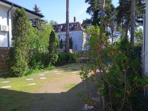 a house in the background with a yard at Balaton-Lak Apartmanház in Siófok