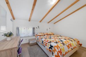 1 dormitorio con cama y mesa de madera en Apartments Čikat Mali Lošinj en Mali Lošinj