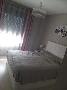 1 dormitorio con cama blanca y ventana en Apartamento Almijara, en Torre del Mar
